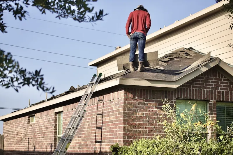 Professional roofer working on a residential roof in West Point